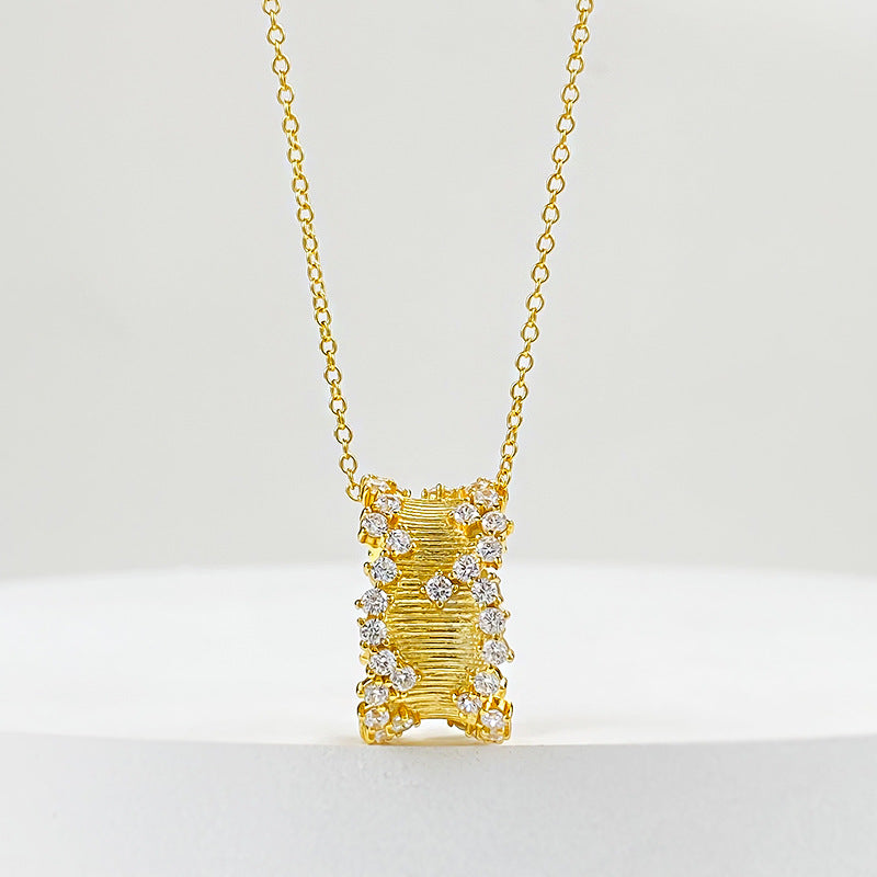 Golden hourglass pendant necklace in brushed gold with cubic zirconia embellishments on a delicate chain.