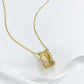 Golden hourglass pendant necklace in brushed gold with cubic zirconia, symbolizing elegance and strength.